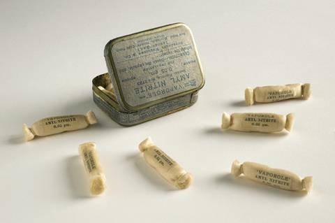 A photo of a small a tin and laid out next to it a few ampoules wrapped in white cloth, bearing the inscription 'Vaporole, amyl nitrite, 0.05 gm'