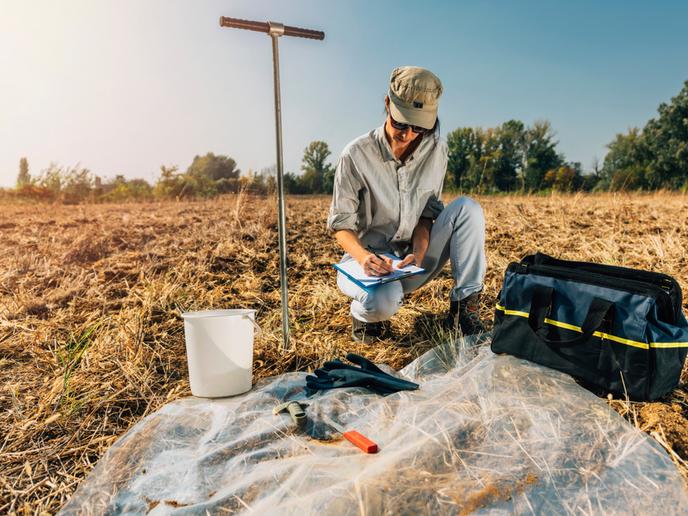 Soil test: An agronomist takes notes in the field. Environmental protection, organic soil certification, research © FCC AQUALIA SA